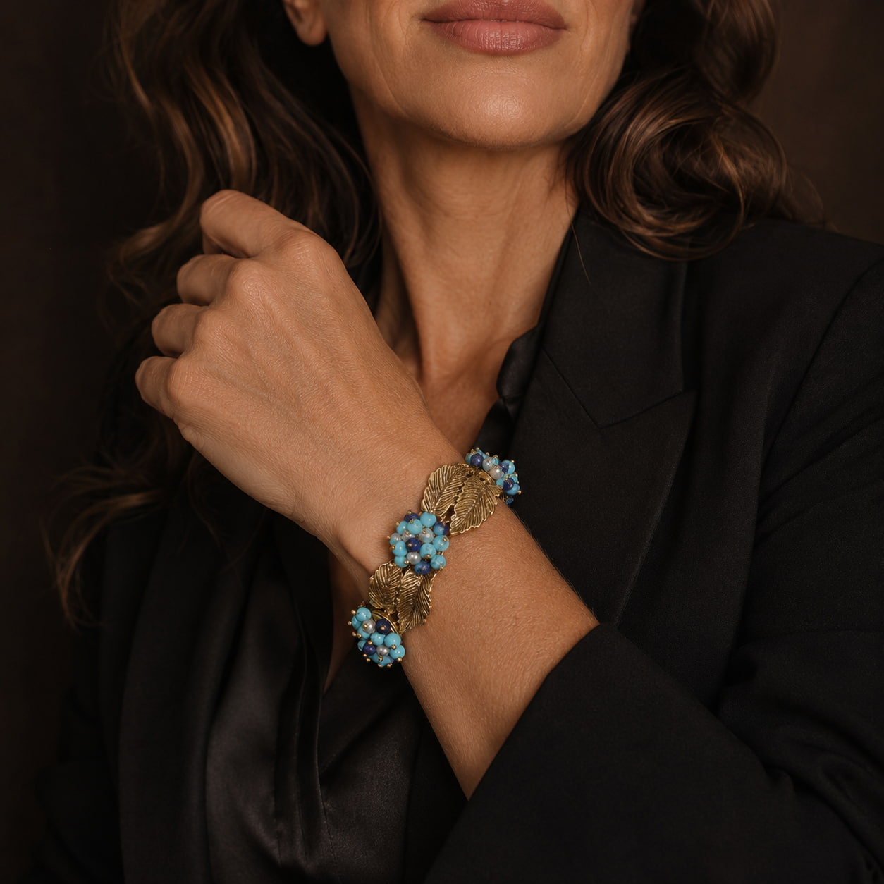 Woman wearing a Retro Style turquoise leaf statement bracelet with a black tailored blazer.