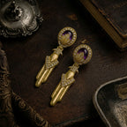 Detailed view of the antiqued gold-tone finish and geometric design on 1980s inspired drop earrings.