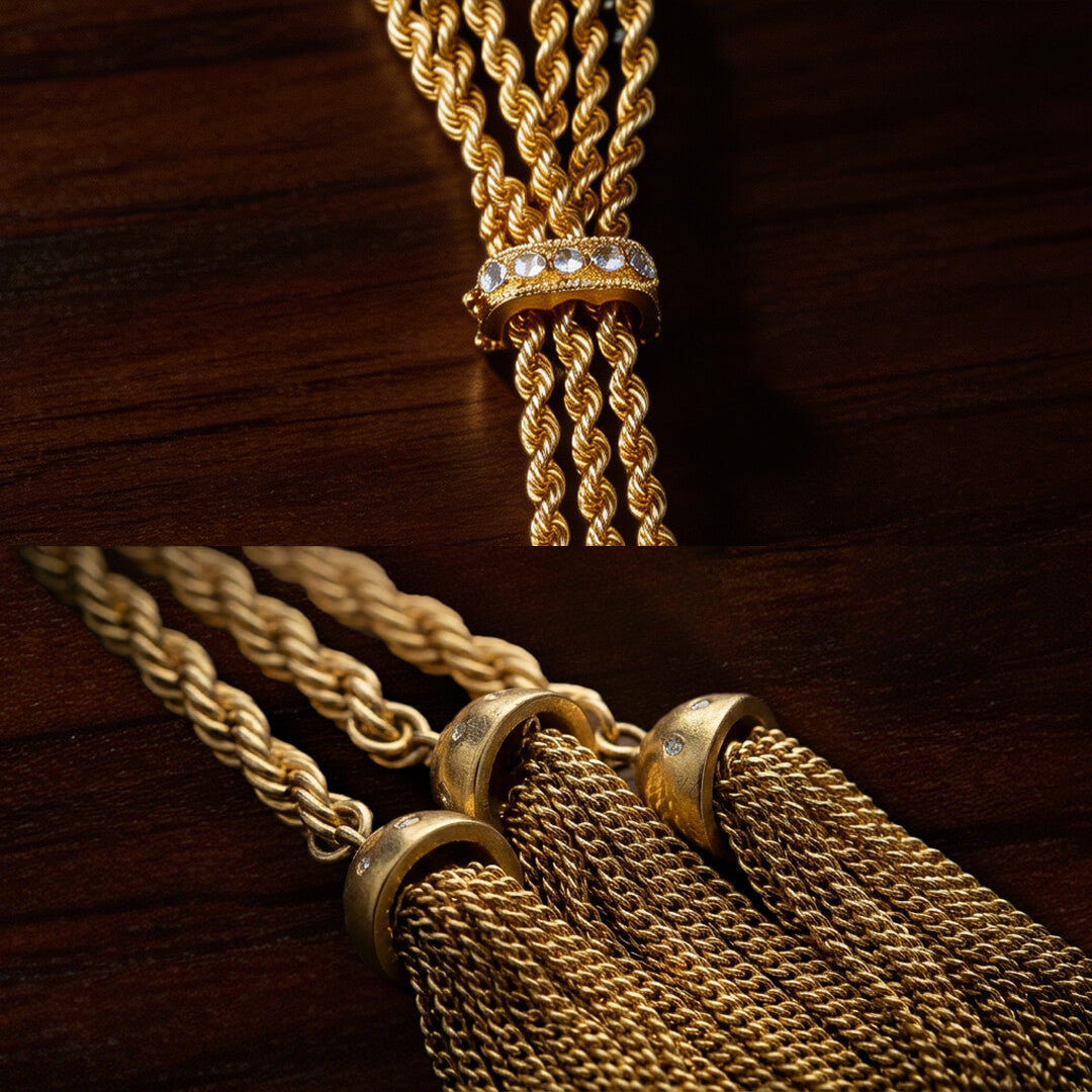 Close up of braided gold chains, a crystal-studded knot, and metallic fringe tassels. Substantial weight bespoke jewelry details with a rich patina.