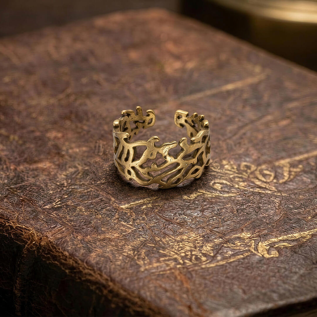 Vintage-inspired chunky gold vine ring resting on an antique leather book.