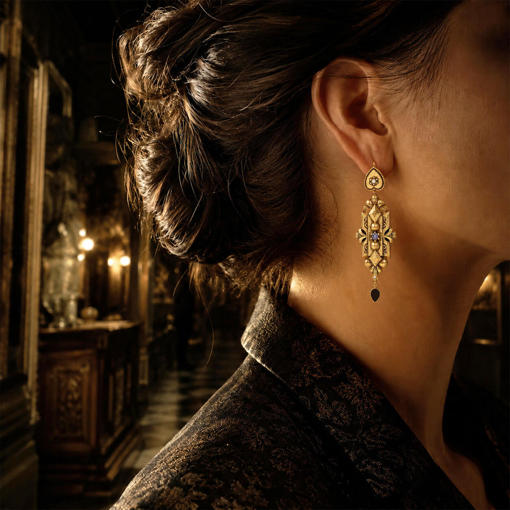 Model wearing long vintage gold statement earrings with dark academia styling.