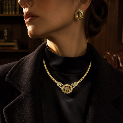 Elegant model wearing Duskcast 1980s runway-inspired citrine gemstone choker necklace and matching oval earrings in a retro library setting.