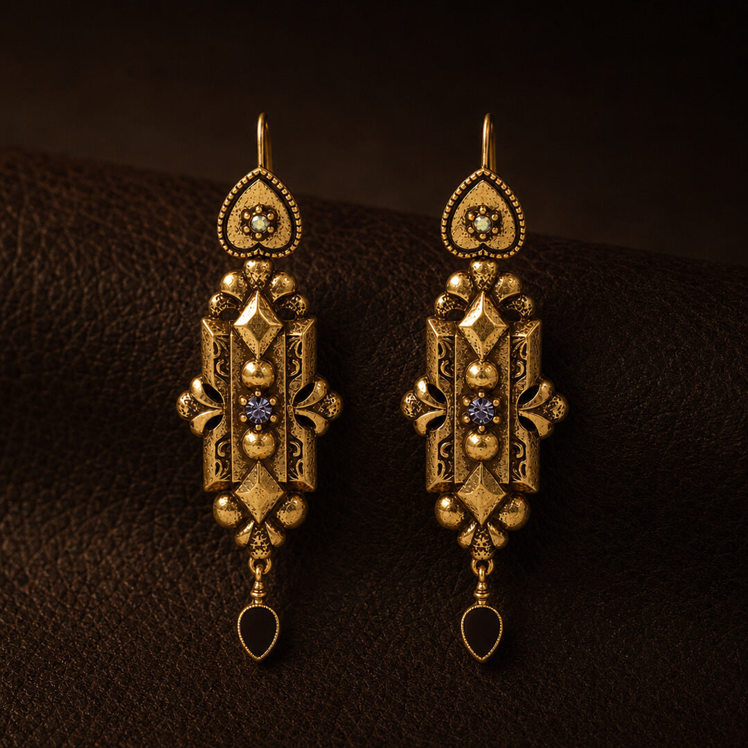 Front view of Duskcast Victorian gold filigree drop earrings with black teardrops.