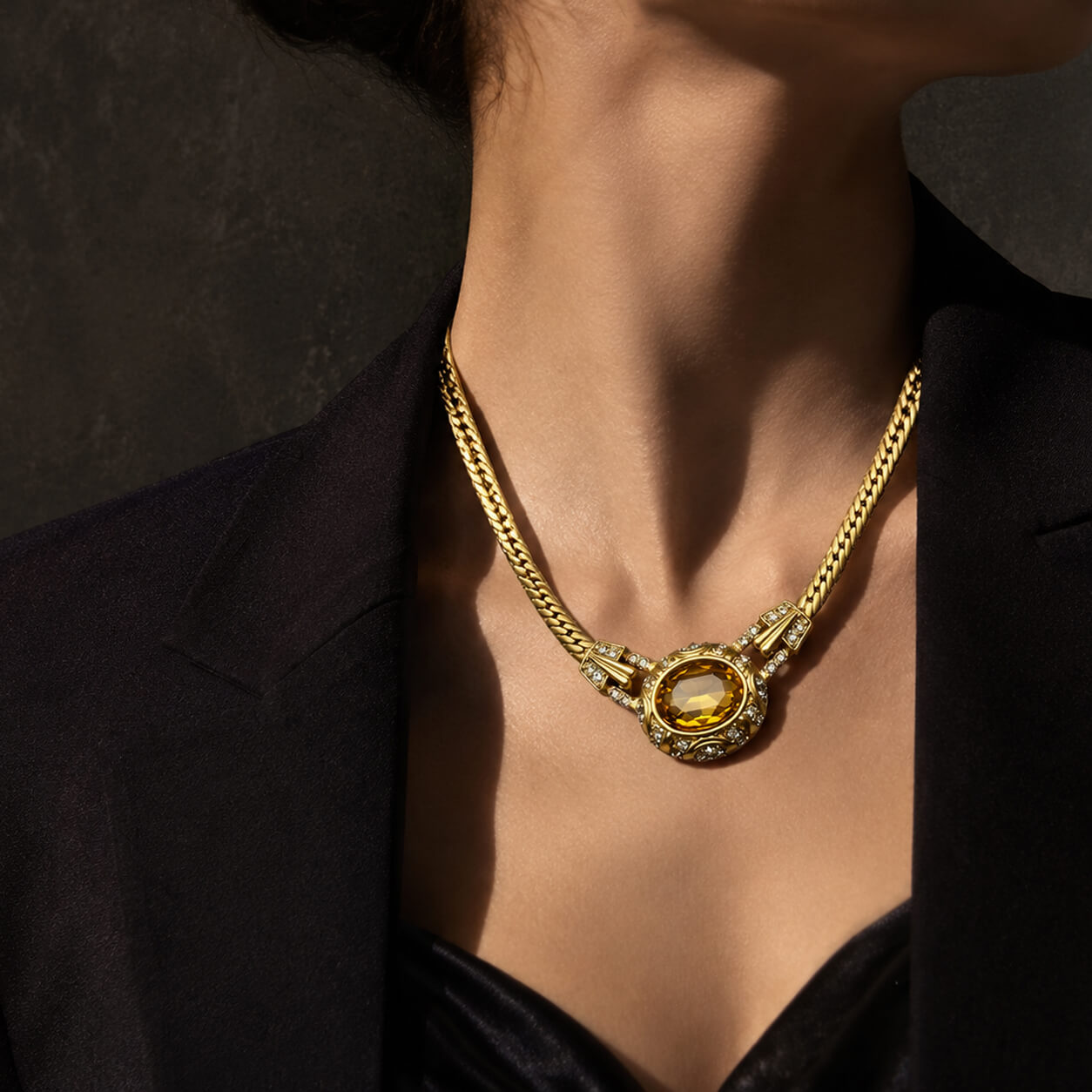 Detailed view of the 1980s runway style gilded oval crystal statement choker necklace on a model's collarbone.