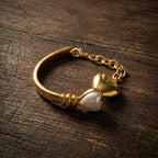 Retro style twin heart bracelet resting on a dark antique wood surface.