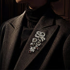 Close-up of the vintage-inspired silver and ruby-colored crystal floral cascading brooch pinned to a dark wool coat.