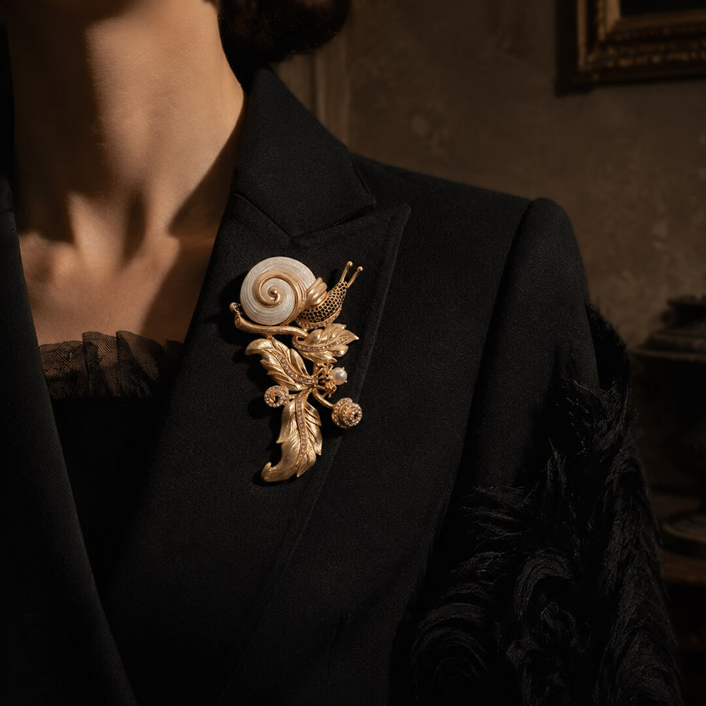 Elegant styling of a large vintage-inspired gold snail brooch on a black evening suit.