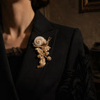Elegant styling of a large vintage-inspired gold snail brooch on a black evening suit.