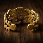 Adjustable vintage-style gold statement ring on a dark wooden surface.