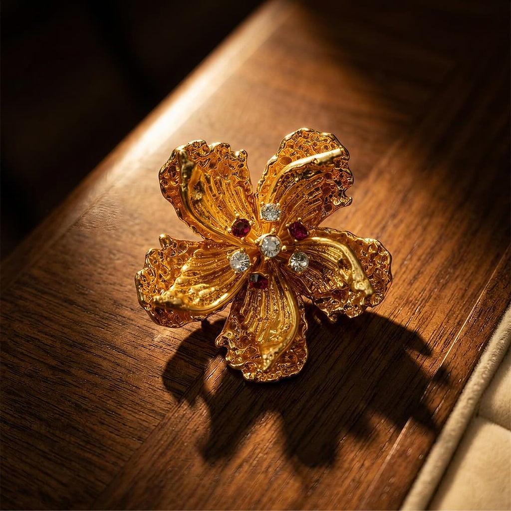 Retro Style gold alloy floral brooch with zircon accents on warm wood display