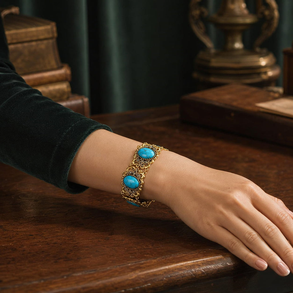 Retro Style turquoise filigree statement bracelet worn on the wrist in a dark vintage setting.