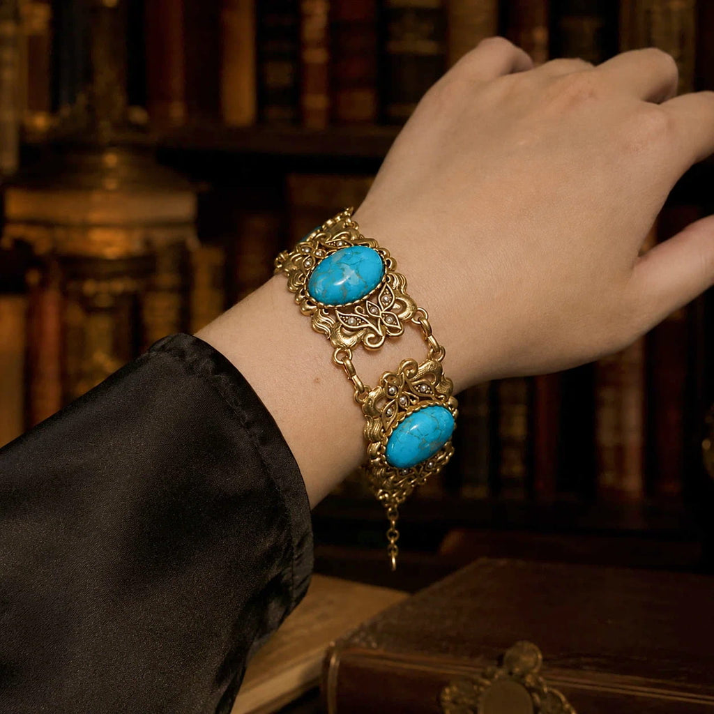 Woman wearing a Vintage-Inspired turquoise filigree statement bracelet with a black sleeve.