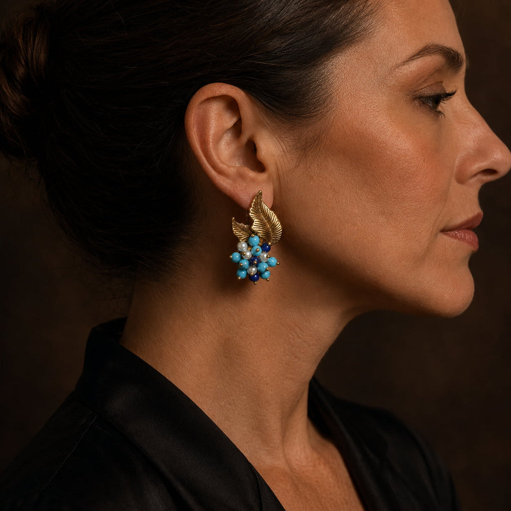 Woman wearing Vintage-Inspired turquoise leaf statement earrings with a black evening outfit.